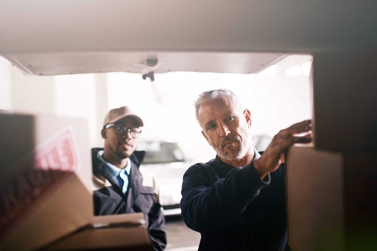 Delivery men loading boxes into a vehicle